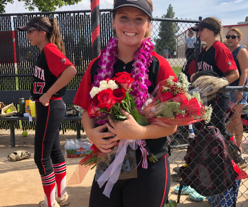 Alexis Detwiler in uniform after game holding roses