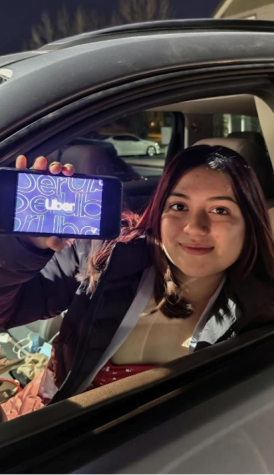 Jadira Dressler sitting in car holding phone with Uber app on it