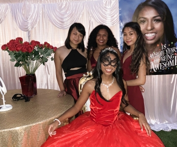 Katelyn Vengersammy in fancy red dress with three girl cousins and red roses behind her for Debut party.