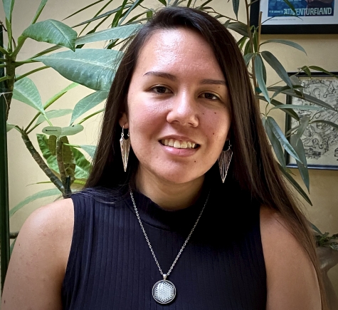 Photo of Leonor Bright, long straight dark hair, silver dangly earrings and necklace, smiling