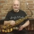 Norbert Stachel with saxophone, sitting white beard, small smile
