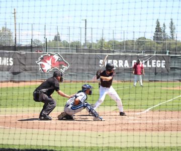 Sierra College Sports baseball player, Bradley Morris prepares to swing his bat in a game, sunny day, other players on the field at Sierra College