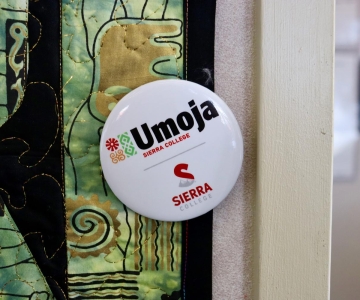 Umoja button pinned to quilt on wall