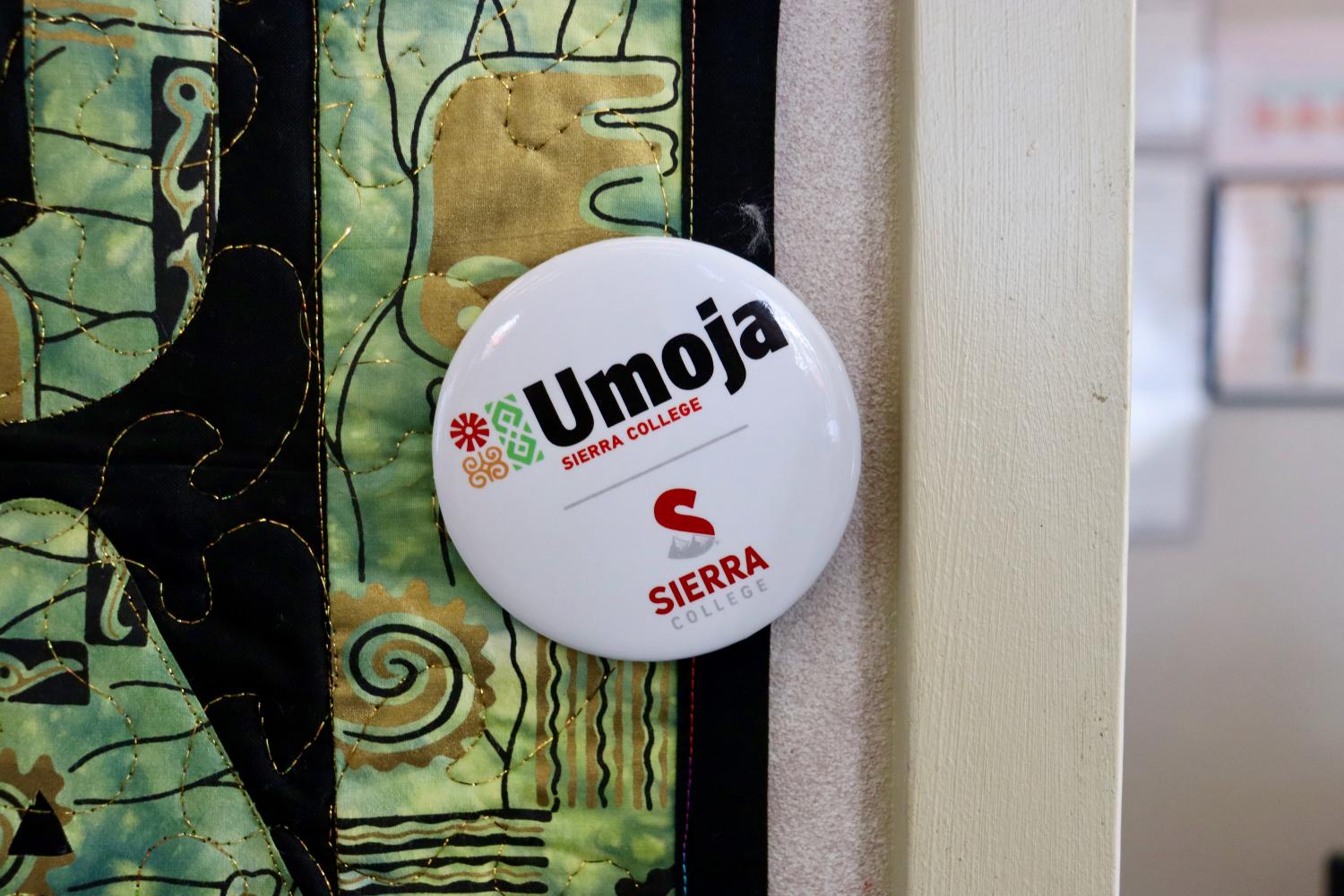 Umoja button pinned to quilt on wall