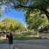 Rocklin campus quad with green grass and trees, person walking in foreground