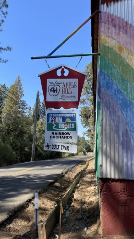 Two signs for Apple Hill business hang from metal building