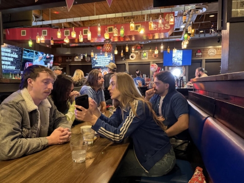 people sitting a long table in decorated restaurant 